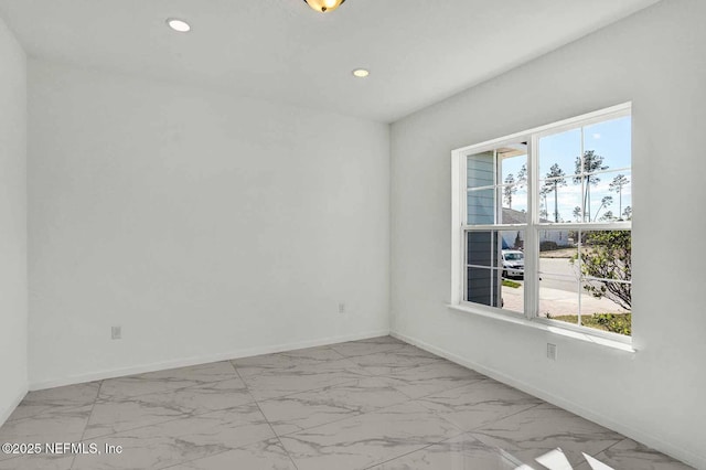 unfurnished room featuring recessed lighting, marble finish floor, and baseboards