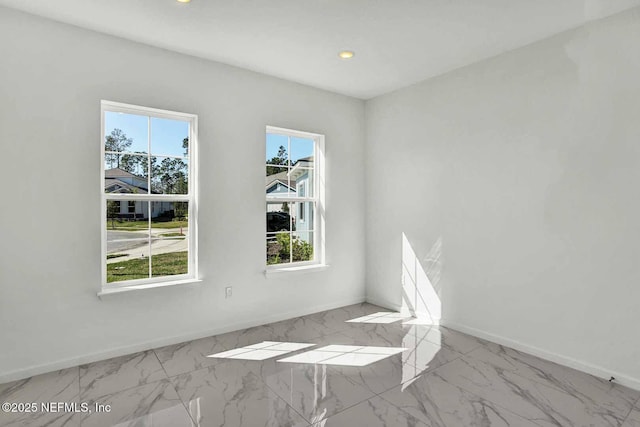 spare room featuring recessed lighting, baseboards, and marble finish floor