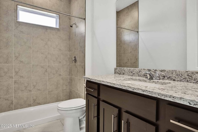 bathroom featuring vanity, toilet, and tiled shower