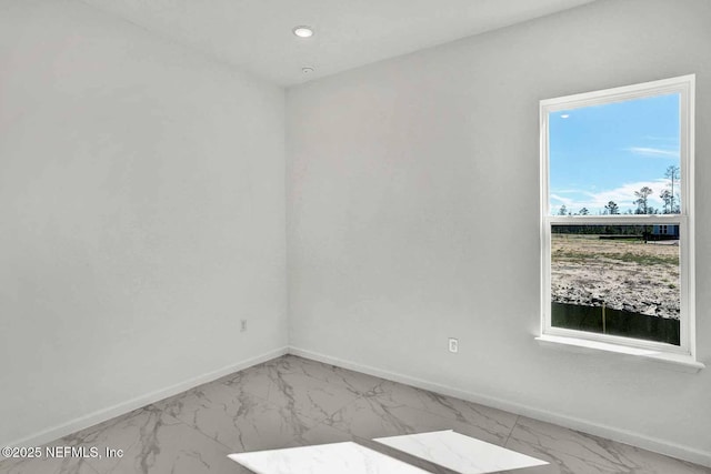 spare room featuring recessed lighting, baseboards, and marble finish floor