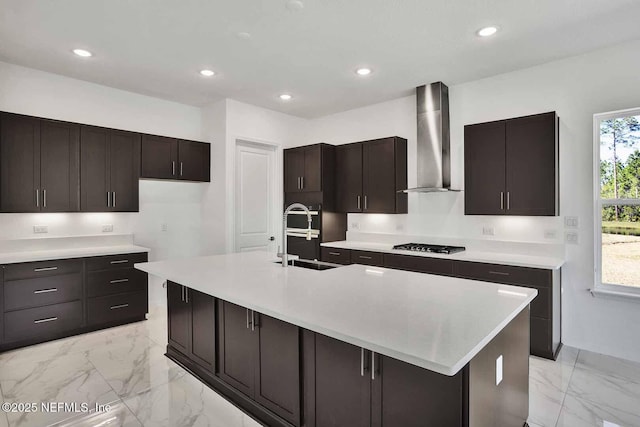 kitchen featuring a wealth of natural light, marble finish floor, black gas stovetop, and wall chimney exhaust hood