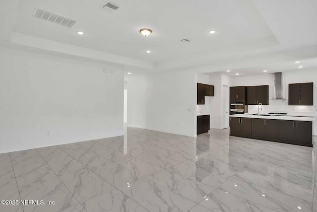 interior space featuring a raised ceiling, recessed lighting, and visible vents