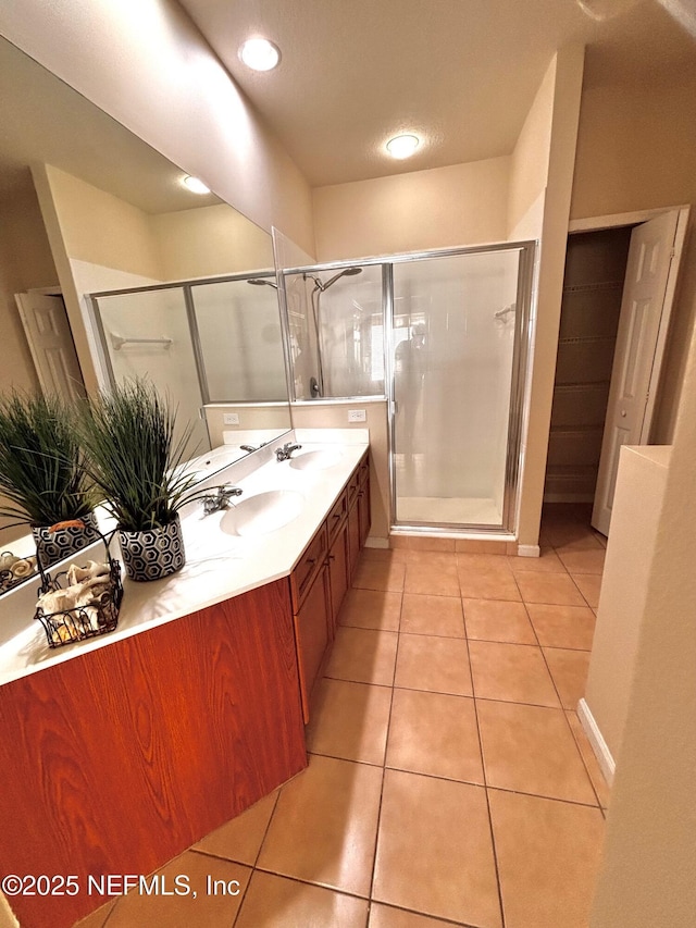 bathroom featuring walk in shower, vanity, and tile patterned flooring