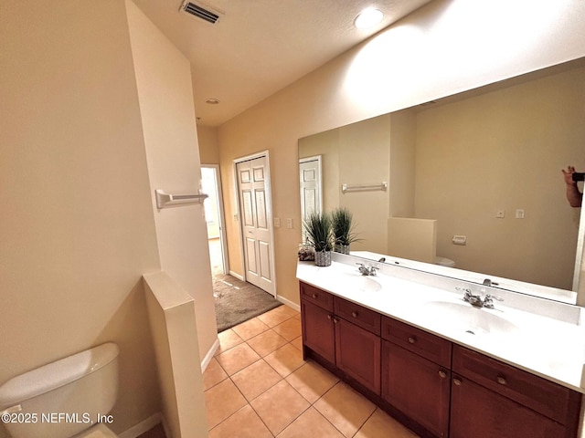 bathroom featuring toilet, tile patterned floors, and vanity