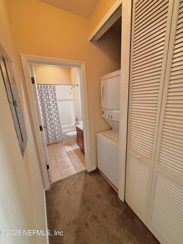 clothes washing area featuring light colored carpet and stacked washer and dryer