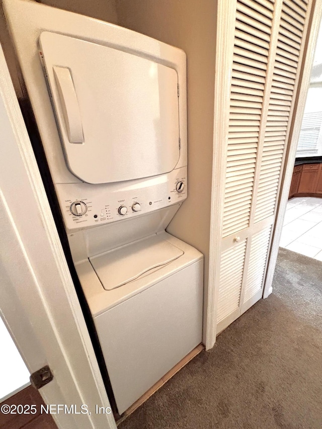 washroom featuring carpet flooring and stacked washer / drying machine