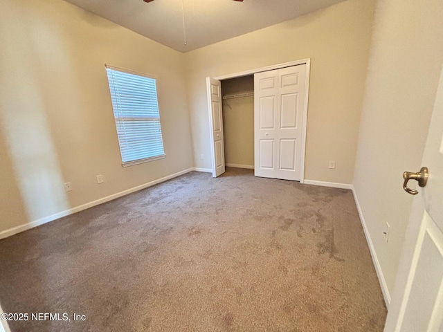 unfurnished bedroom featuring ceiling fan, a closet, and carpet flooring