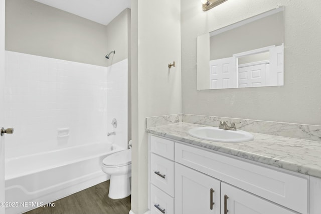 full bathroom with toilet, tub / shower combination, wood-type flooring, and vanity