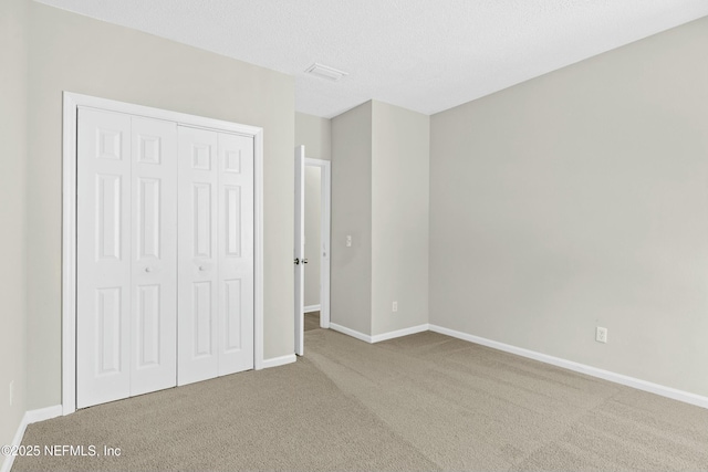 unfurnished bedroom with carpet floors, a closet, and a textured ceiling