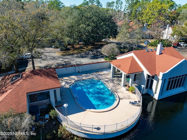 view of pool featuring a water view and a patio