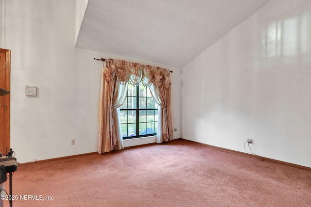 carpeted spare room featuring vaulted ceiling