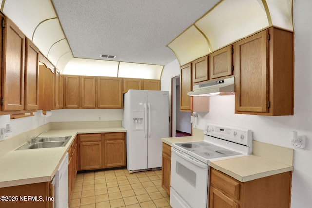 kitchen featuring light tile patterned flooring, white appliances, sink, and a textured ceiling