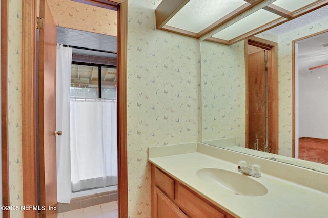 bathroom featuring tile patterned flooring, vanity, and curtained shower