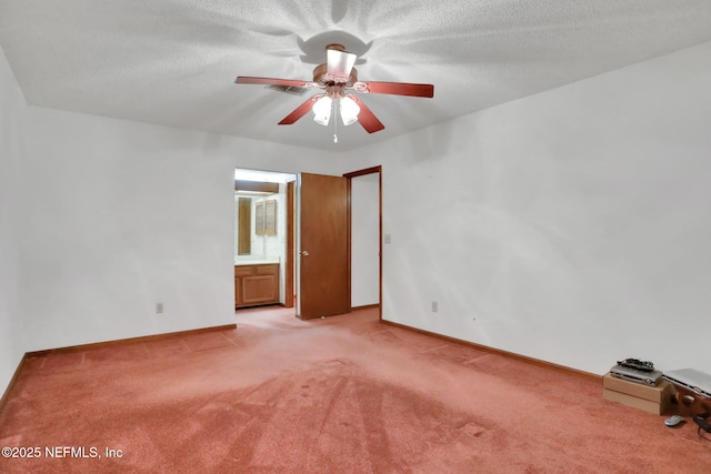 interior space featuring ensuite bathroom, light colored carpet, a textured ceiling, and ceiling fan