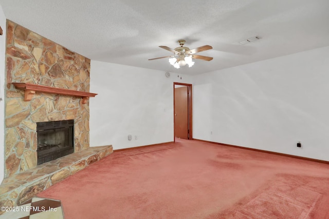 unfurnished living room featuring ceiling fan, carpet flooring, a textured ceiling, and a fireplace