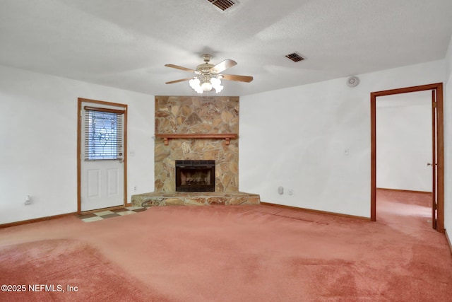 unfurnished living room with ceiling fan, carpet flooring, a textured ceiling, and a fireplace