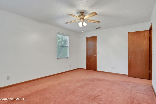 unfurnished room featuring ceiling fan, light carpet, and a textured ceiling