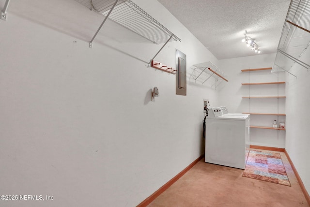 washroom featuring washer / clothes dryer, electric panel, and a textured ceiling