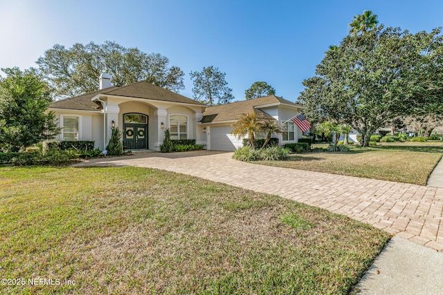 view of front of property with a garage and a front lawn