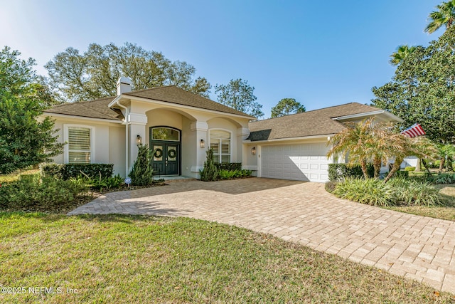 view of front of house with a garage, a front lawn, and french doors