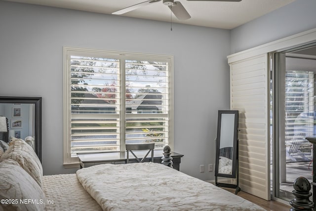 bedroom with multiple windows, hardwood / wood-style flooring, and ceiling fan