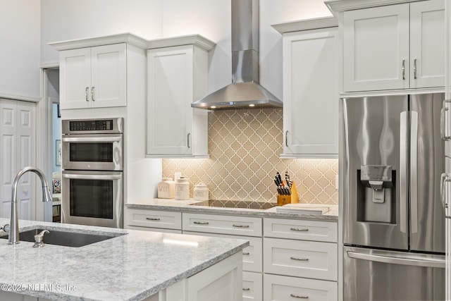 kitchen with white cabinetry, wall chimney range hood, stainless steel appliances, and sink