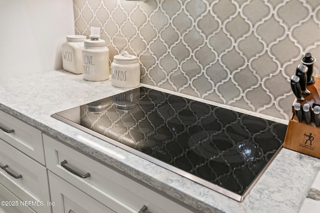 details with white cabinetry and black electric stovetop