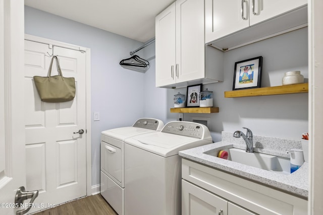 washroom with sink, dark wood-type flooring, cabinets, and independent washer and dryer