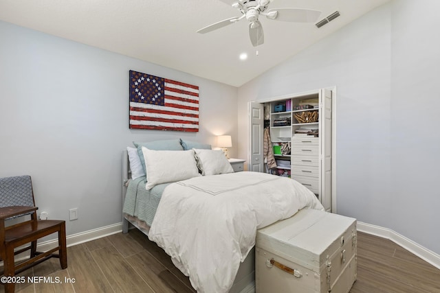 bedroom with ceiling fan, lofted ceiling, dark hardwood / wood-style flooring, and a closet