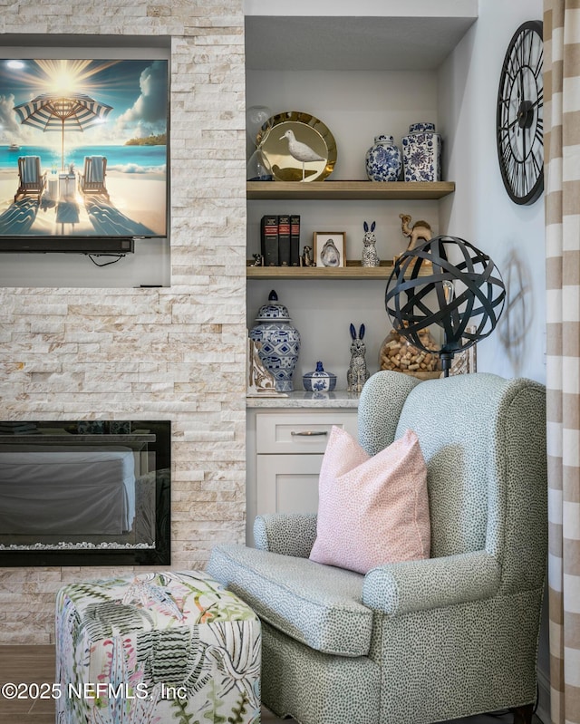 sitting room with a stone fireplace