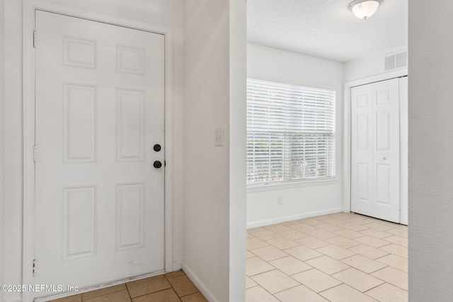 tiled foyer with a textured ceiling