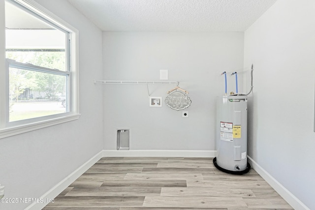 clothes washing area with washer hookup, water heater, plenty of natural light, and hookup for an electric dryer