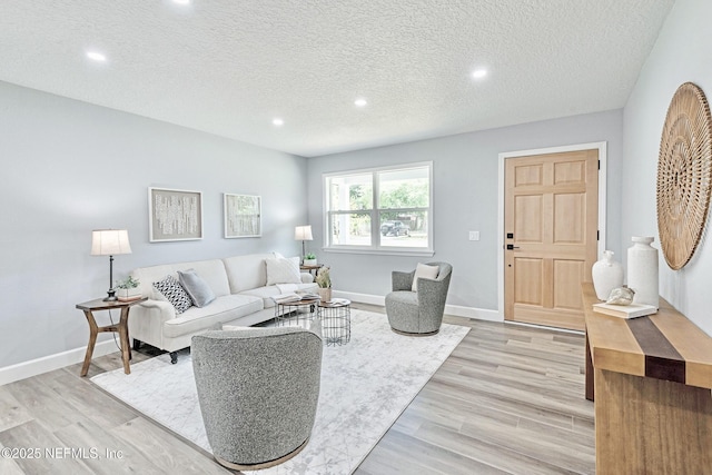 living room featuring a textured ceiling and light hardwood / wood-style floors