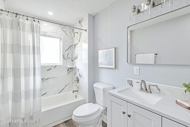 full bathroom with shower / bath combo with shower curtain, a textured ceiling, toilet, and vanity