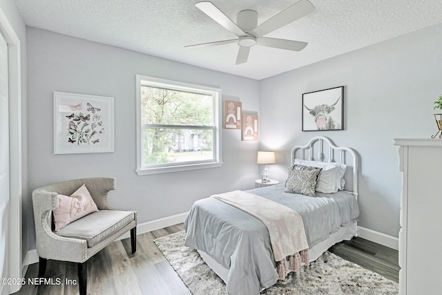 bedroom featuring ceiling fan, light hardwood / wood-style floors, and a textured ceiling