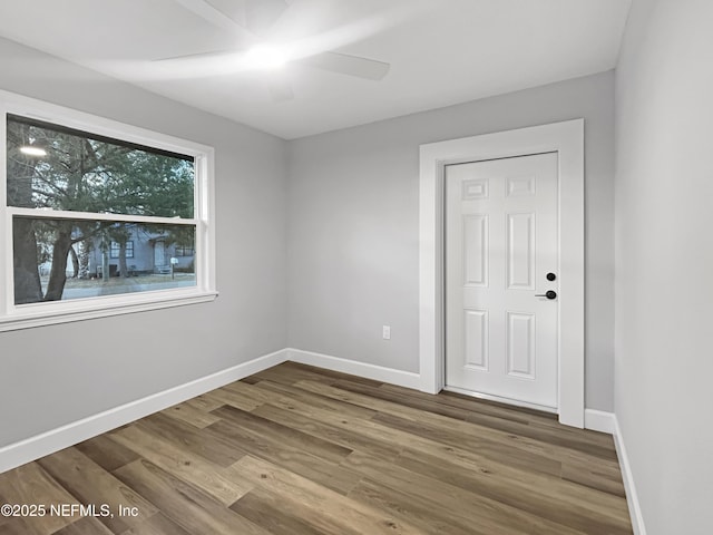 empty room with ceiling fan and hardwood / wood-style flooring