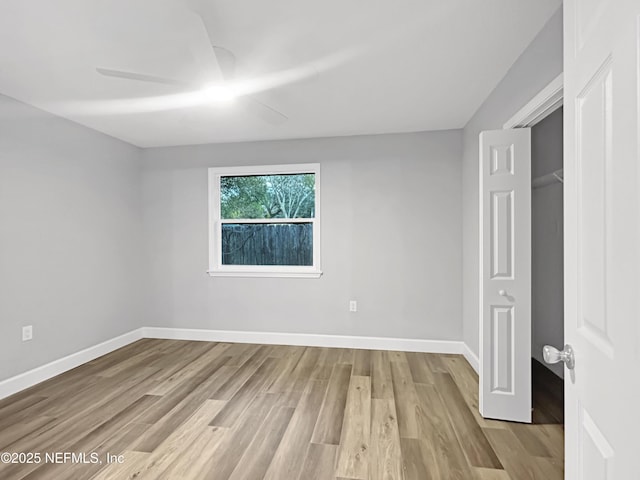 unfurnished bedroom featuring ceiling fan, a closet, and light wood-type flooring