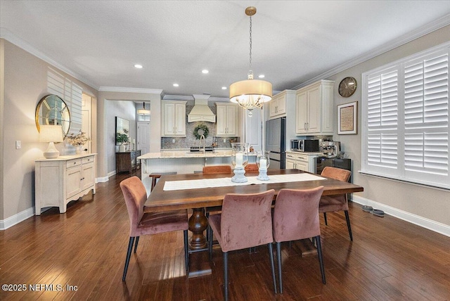 dining space featuring dark wood-type flooring, ornamental molding, and an inviting chandelier