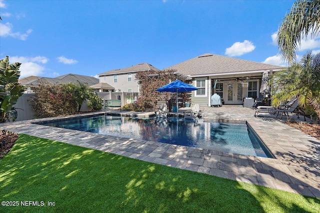 view of swimming pool with ceiling fan, a patio area, and a yard