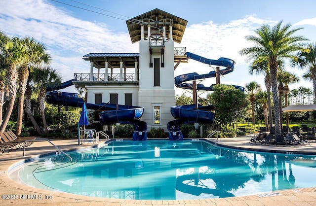 view of pool with a water slide and a patio