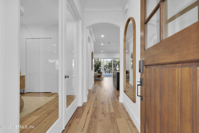 hall featuring light hardwood / wood-style floors and ornamental molding