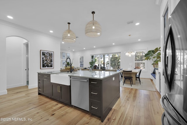 kitchen featuring black fridge, sink, dishwasher, and decorative light fixtures