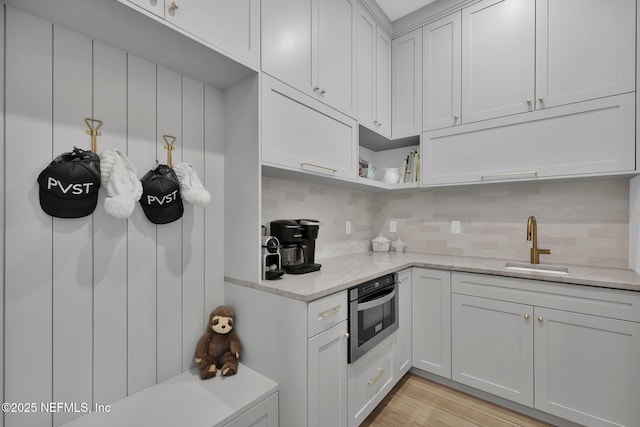 kitchen with light stone countertops, white cabinets, and stainless steel oven