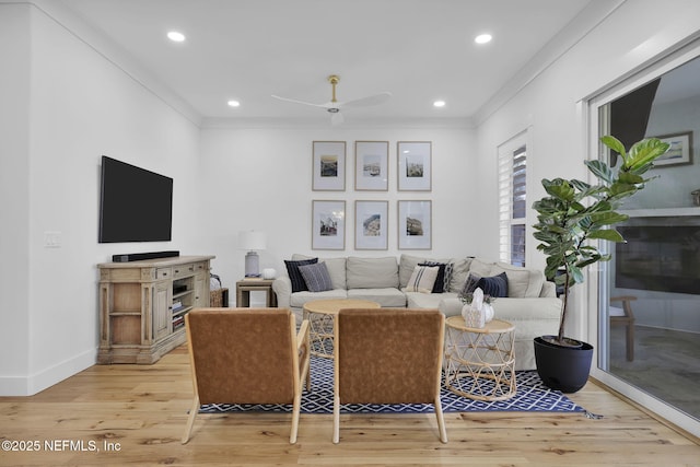 living room with ceiling fan, wood-type flooring, and crown molding