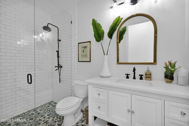 bathroom with toilet, vanity, and a shower with door