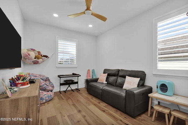 living room featuring ceiling fan and light hardwood / wood-style flooring