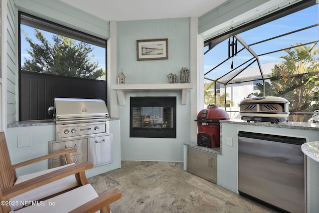 view of patio / terrace with grilling area, a lanai, and exterior kitchen