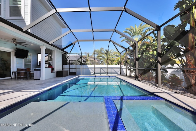 view of swimming pool with ceiling fan, a lanai, and a patio area