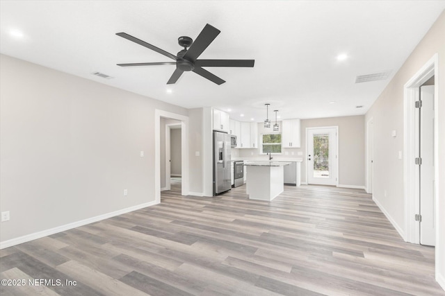 unfurnished living room with ceiling fan and light hardwood / wood-style flooring