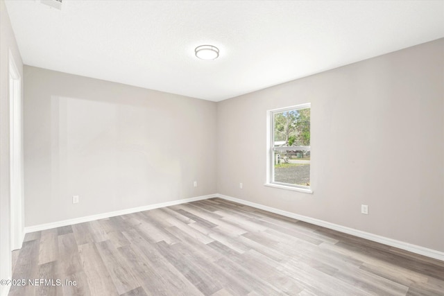 unfurnished room with light wood-type flooring